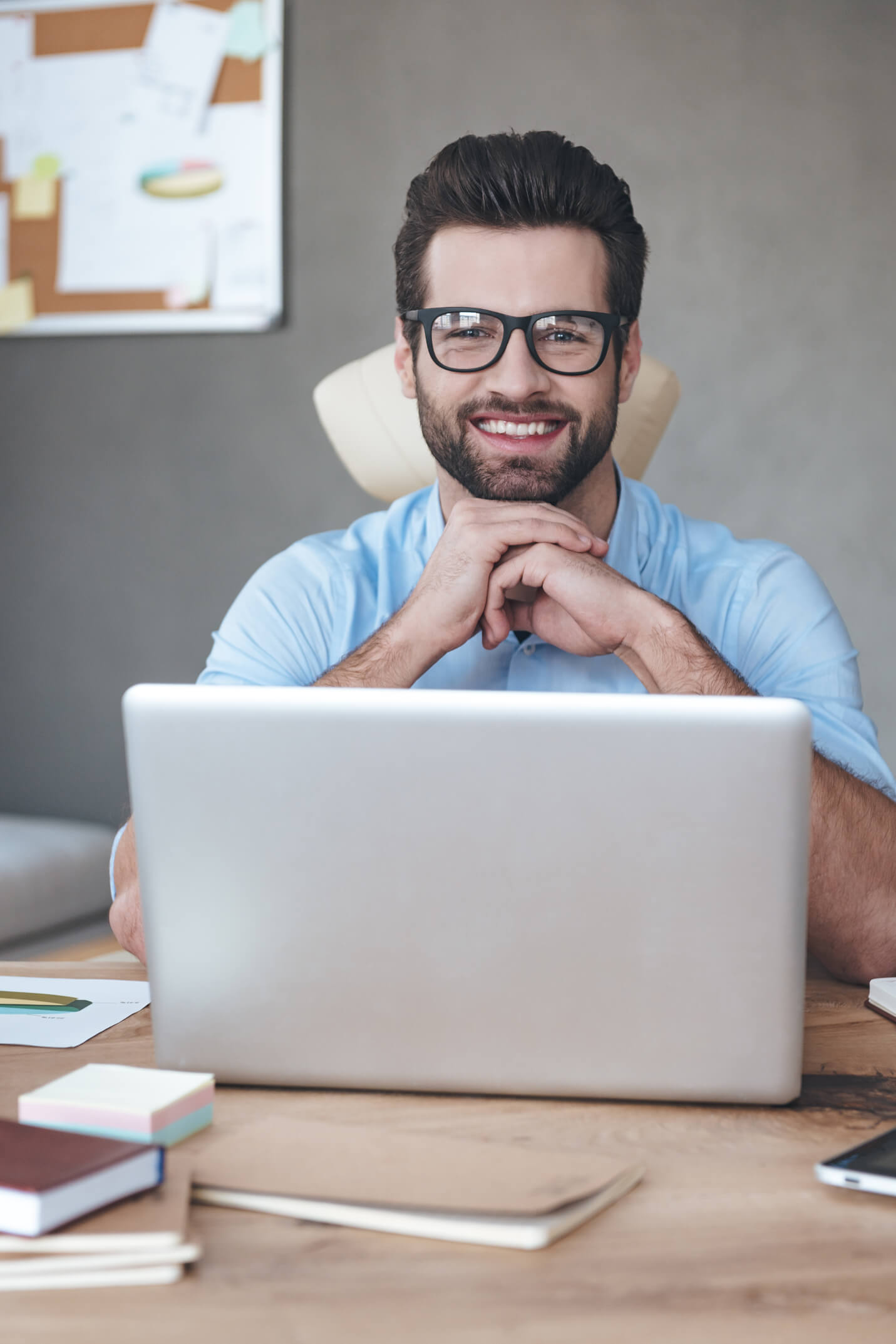 a man sitting at a desk with his hands on his chin